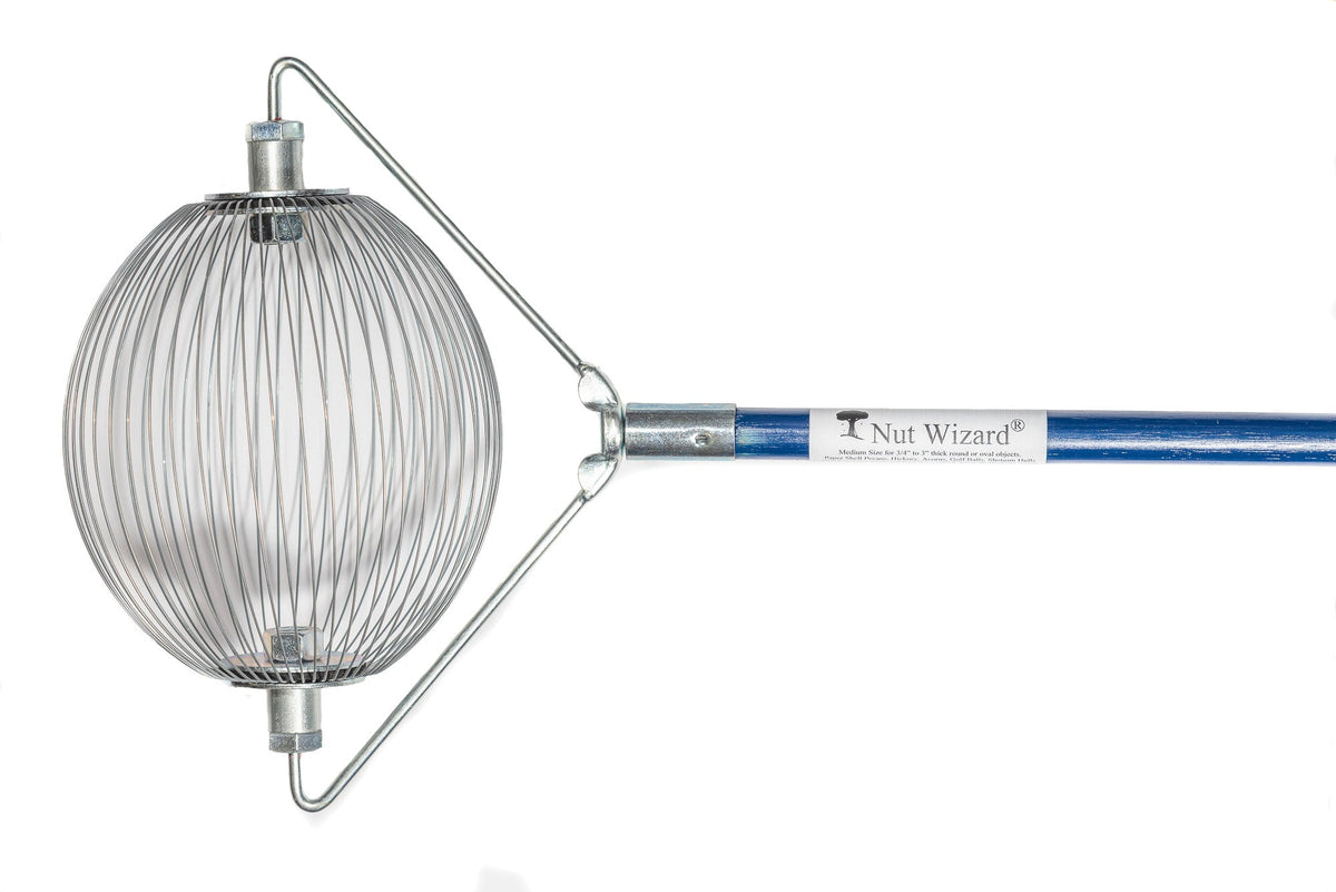 A Medium Nut Wizard® with its many wires that are held together with metal plates to create a "basket,"; The plates have two large bolts sticking out on either end. The bolts are attached to a “bail,” a thin metal wire-type part bent in three points with a threaded piece in the center that attaches the Nut Wizard® basket to a blue, four-foot wooden handle. The handle has a white label with a tree and the words "Nut Wizard®" on it.