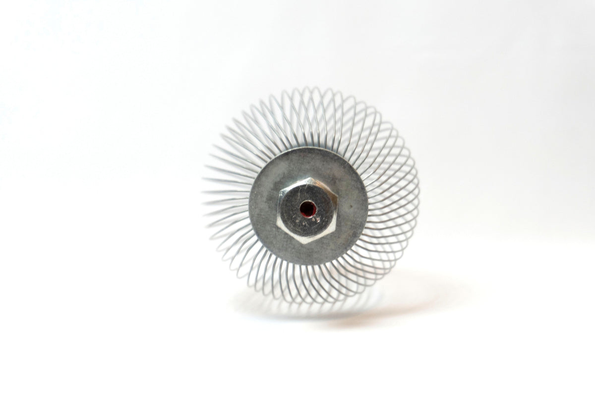 A Nut Wizard basket with many thin wires are held together with metal plates to create a "basket" with two large bolts sticking out on either end.
