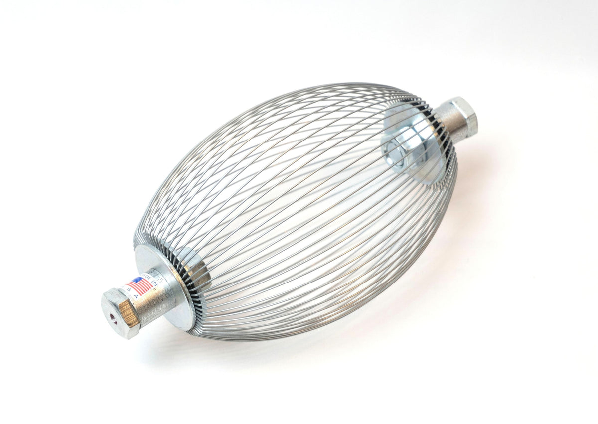 A Nut Wizard basket with many thin wires are held together with metal plates to create a "basket" with two large bolts sticking out on either end. A sticker on one bolt shows an American flag and the words "Made in the USA."
